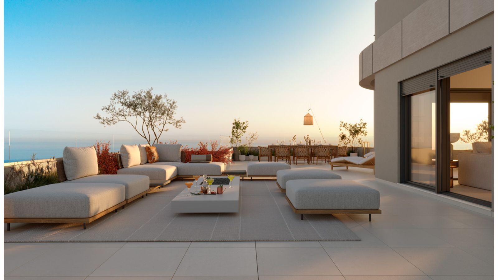 Luxe terras met oceaanzicht, comfortabele loungebanken en een eettafel in de verte.